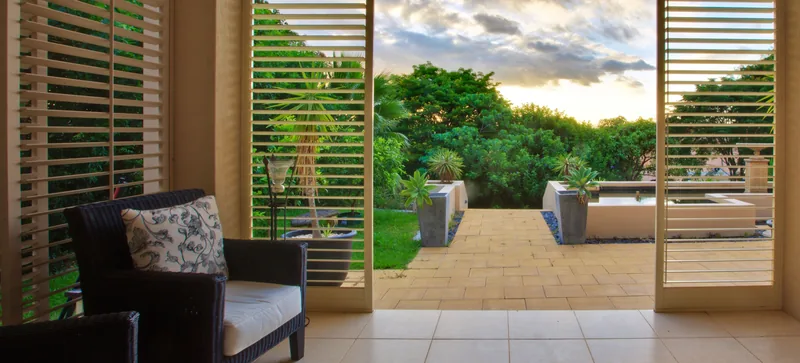 Aluminium shutters shading a poolside outdoor room