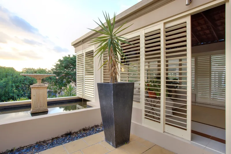 Aluminium plantation shutters shading a poolside outdoor room