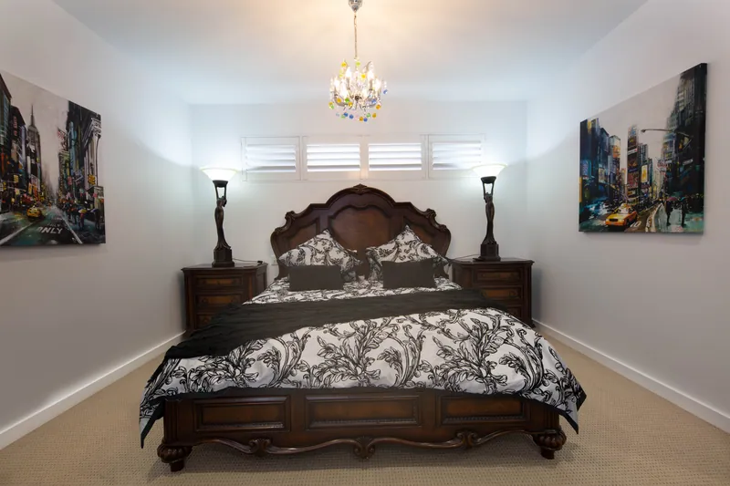 Main bedroom with plantation shutters controlling light behind the bedhead