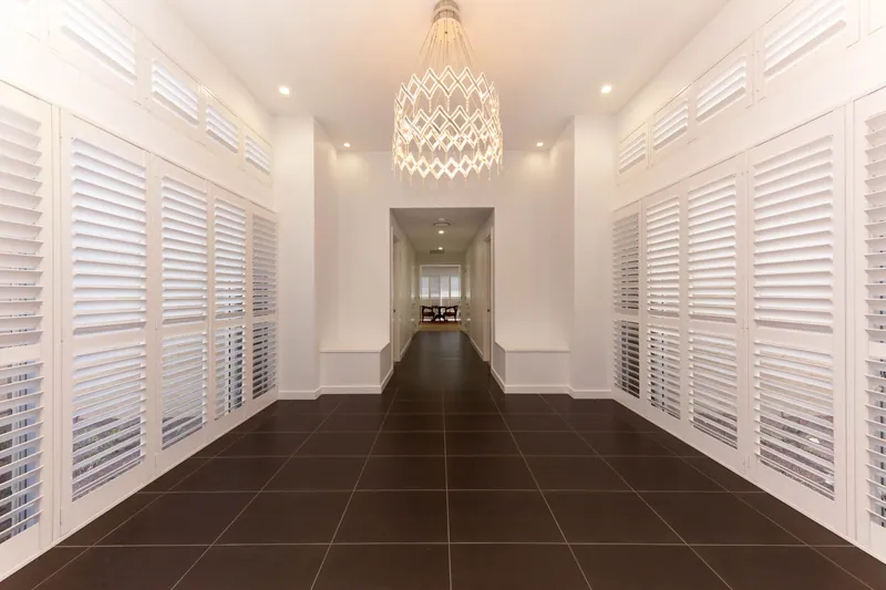 Long hallway with plantation shutters running the full length on both sides