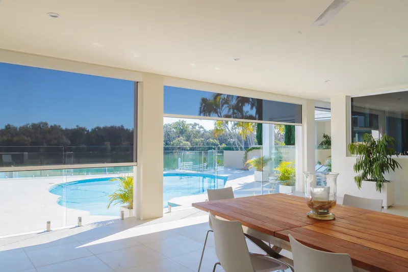 Outdoor dining table under cover with ZipScreens providing shade and wind protection