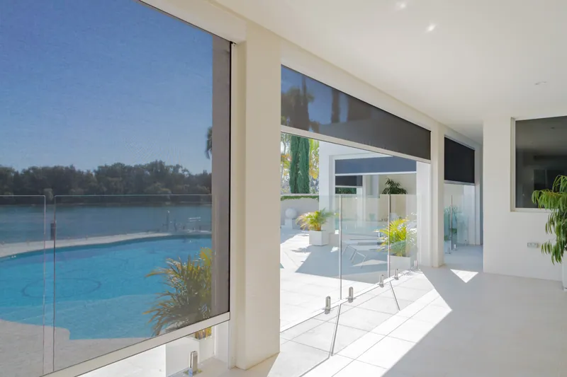 ZipScreens lowered across a poolside entertaining area to block wind and sun
