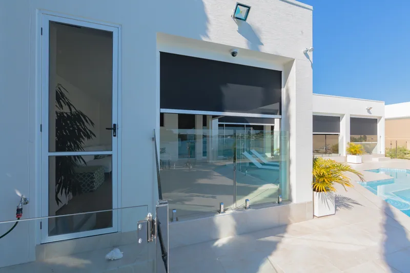 Poolside lounge setting with outdoor screens partly lowered
