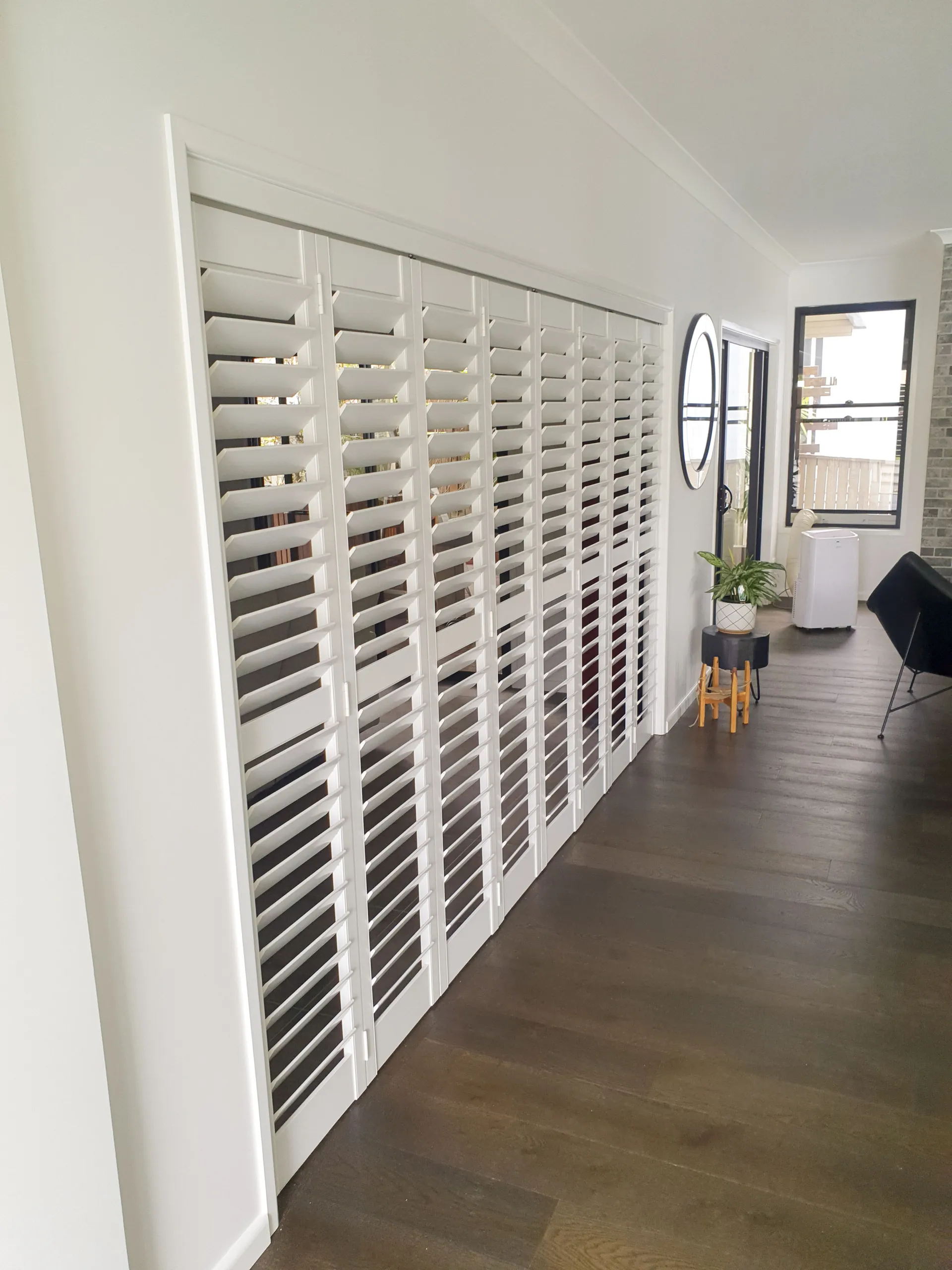 Contemporary Brisbane living room fitted with white Thermalite plantation shutters