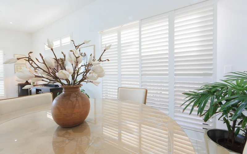 White Thermalite plantation shutters in a sunlit Brisbane living and dining room