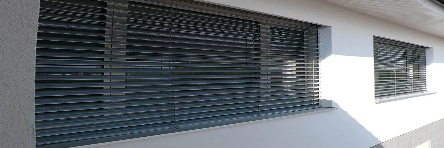 External venetian blinds with adjustable aluminium slats shading a modern home facade
