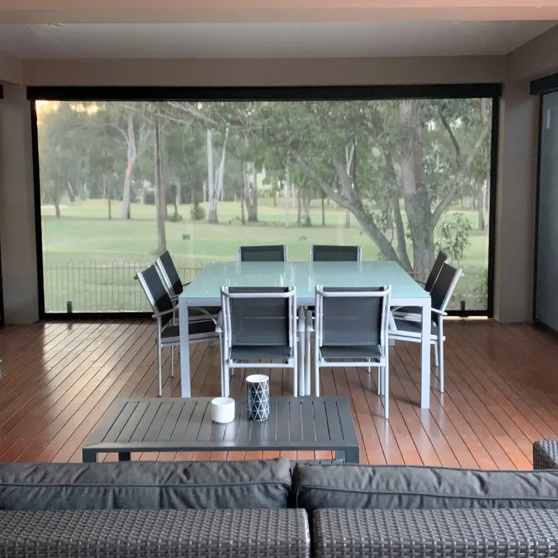 ZipScreen outdoor blind lowered across an alfresco patio, shading the space from sun and wind